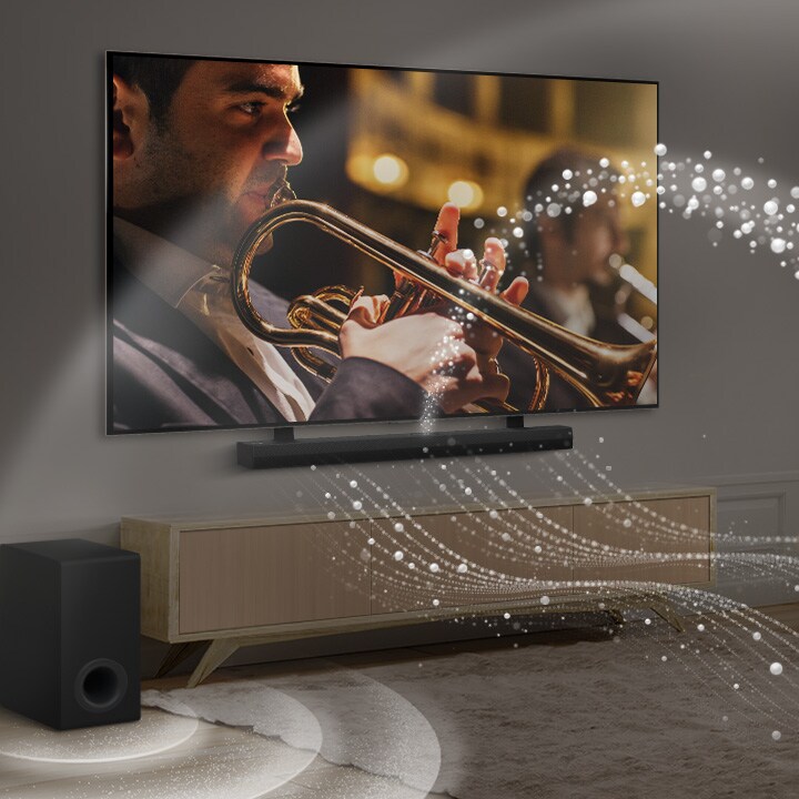 LG Soundbar, LG TV und ein Subwoofer stehen in einer modernen Stadtwohnung. Die LG Soundbar strahlt Schallwellen aus weißen Tröpfchen aus, die den Raum füllen, und ein Subwoofer erzeugt einen Klangeffekt von unten. Gemeinsam erzeugen sie einen Kuppeleffekt im Raum.