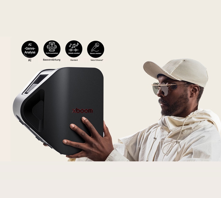 will.i.am, con un atuendo blanco y una gorra blanca, está sosteniendo el xboom Stage 301 con ambos brazos frente a su cara.