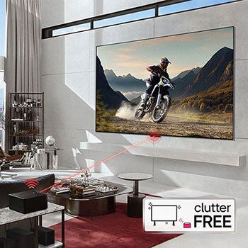 Zero Connect Box im Wohnzimmer, überträgt kabellos ein Motorradvideo auf den an der Wand montierten LG Signature OLED M4 True Wireless TV Fernseher.