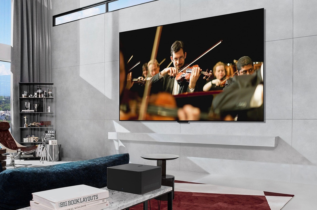 Zero Connect Box auf einem Tisch in einem luxuriösen Wohnzimmer streamt eine Orchesteraufführung auf den LG OLED evo AI M4 4K Smart TV Fernseher.