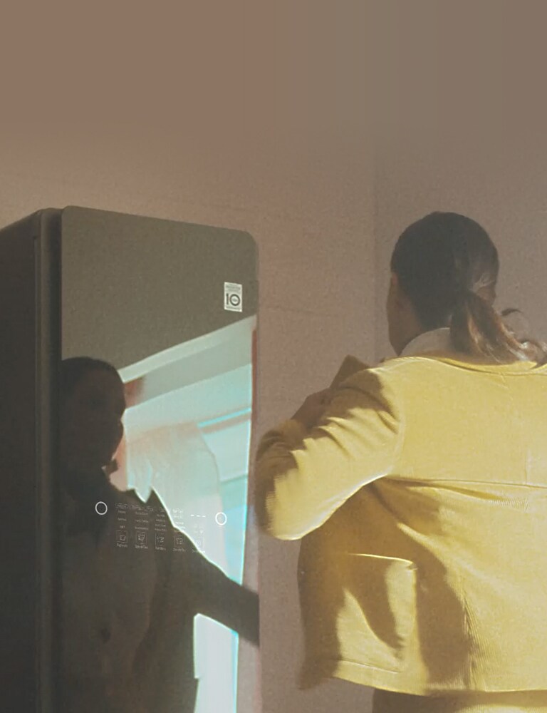 Eine Frau nimmt ihre Jacke aus dem LG Styler, um zur Arbeit zu gehen