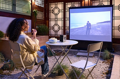 Ein Gast sieht einen Film auf einer Leinwand mit CineBeam