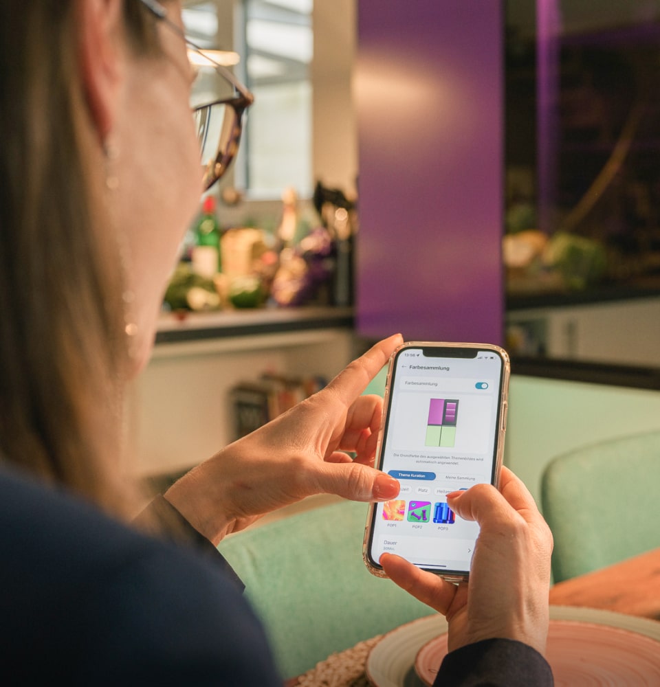 Eine Frau nutzt den Farbkollektionsmodus über die ThinQ-App.
