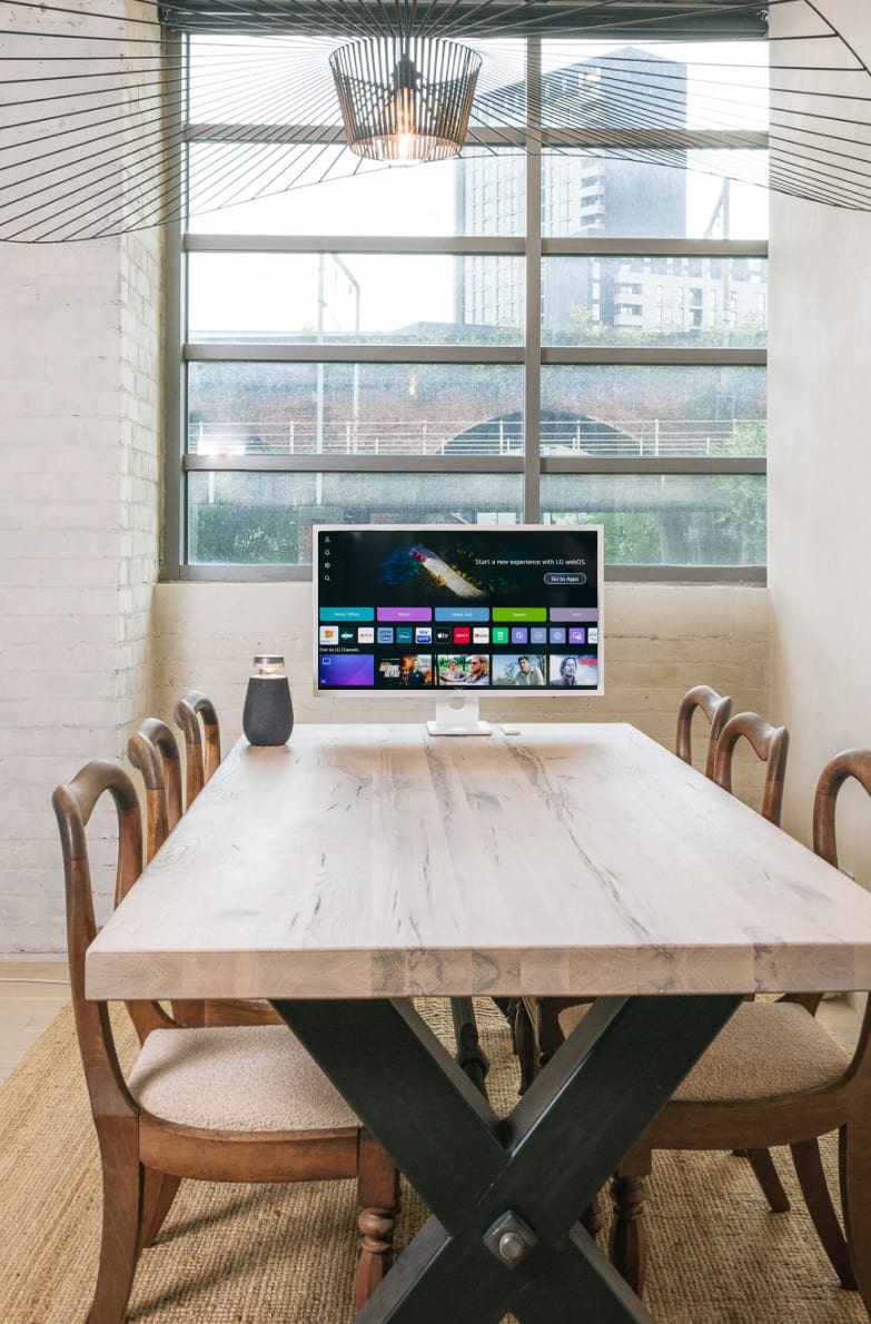 Al bancone della sala da pranzo, il LG MyView Smart Monitor e il Xboom XO2T sono disposti uno accanto all'altro in un ambiente minimalista.