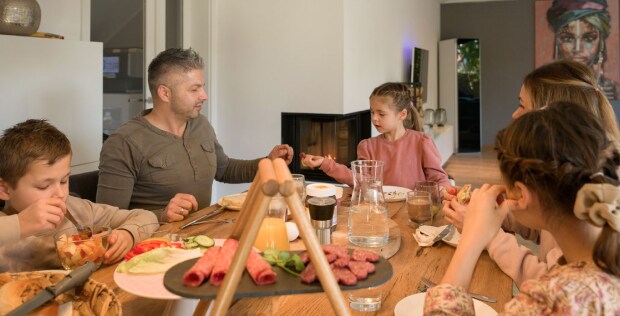 Die Familie sitzt beim Mittagessen am Tisch