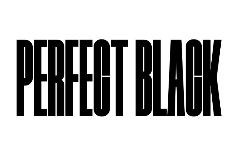 تظهر كلمتي "PERFECT BLACK" (أي أسود فائق) بأحرف كبيرة باللون الأسود الغامق. يتم عرض مشهد لمنطقة جبلية سوداء عالية الوضوح ثم يرتفع المشهد ليغطي الحروف، ويكشف أيضًا عن قرية وكثبان رملية. تختفي النسخة السوداء خلف سماء سوداء.