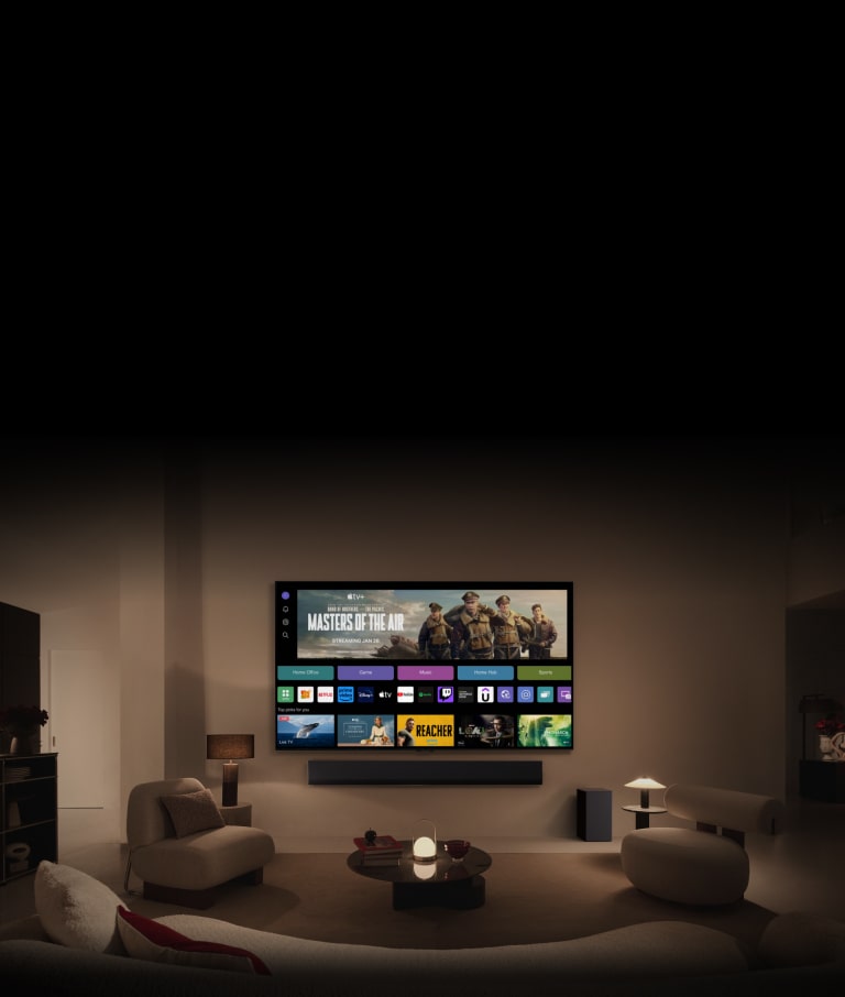 لقطة مقربة لشاشة LG TV تعرض أزرار Home Office وGame وMusic أعلى لافتة لفيلم Masters of the Air، ويتم تصغيرها لإظهار التلفزيون المثبت على الحائط في غرفة المعيشة. يتم عرض الشعارات التالية على شاشة التلفزيون في الصورة: LG Channels وNetflix وPrime Video وDisney TV وApple TV وYouTube وSpotify وTwitch وGeForce Now وUdemy.