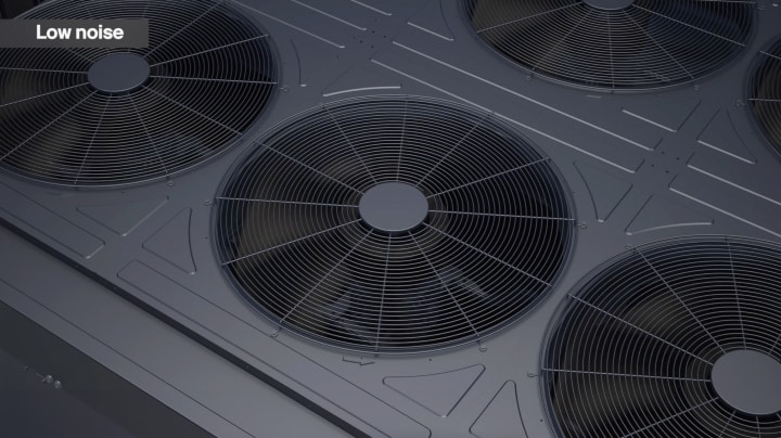 Primer plano de varios ventiladores de refrigeración de gran tamaño con rejillas metálicas.