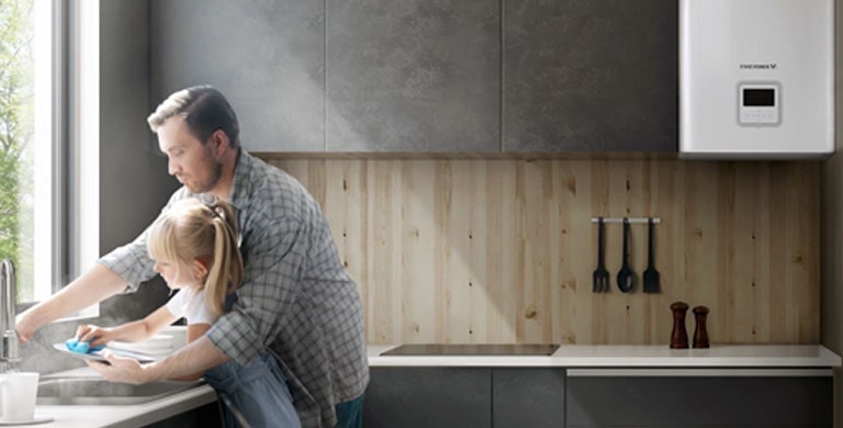 Un padre y su hija lavan los platos con agua caliente en la cocina.