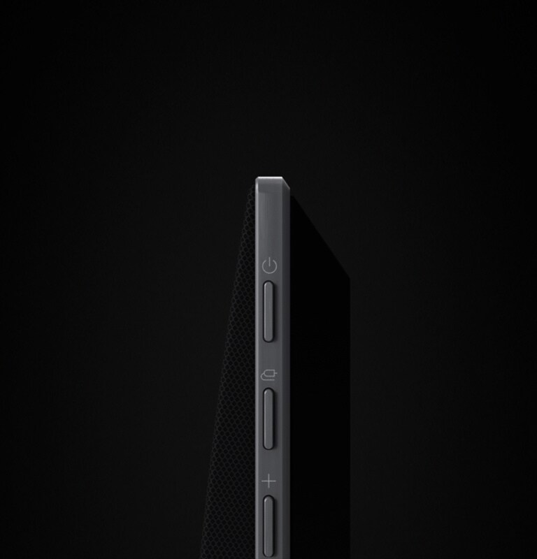 La barra de sonido LG está sobre un fondo negro que revela su diseño comenzando desde la parte superior y moviéndose hacia la esquina. Las gotas blancas se proyectan desde el centro y los extremos de la barra de sonido como una cascada, representando el sonido del disparo.