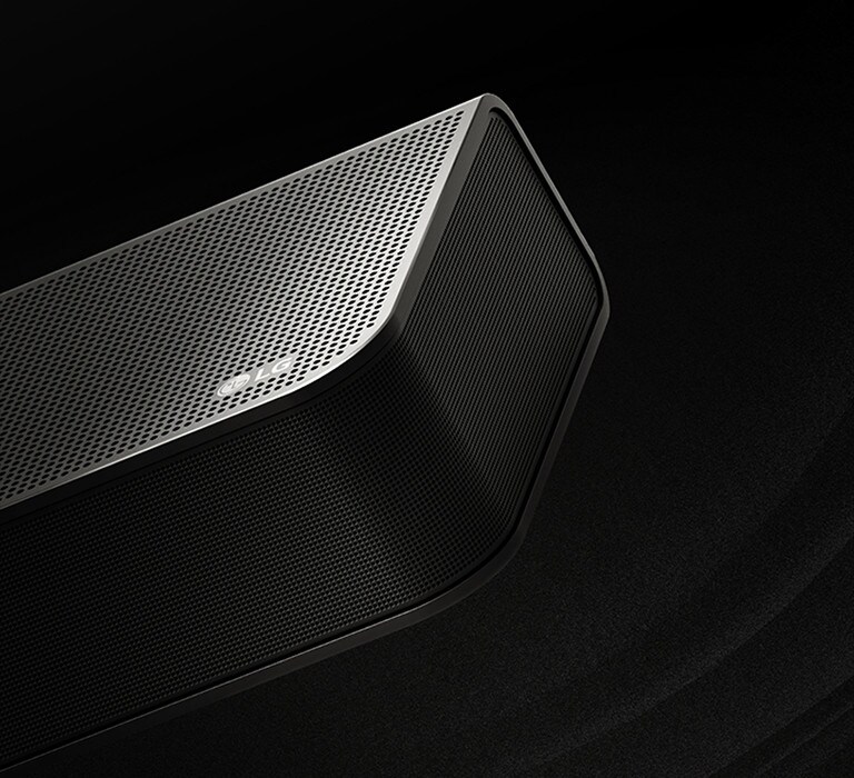 La barra de sonido LG está sobre un fondo negro que revela su diseño comenzando desde la parte superior y moviéndose hacia la esquina. Las gotas blancas se proyectan desde el centro y los extremos de la barra de sonido como una cascada, representando el sonido del disparo.