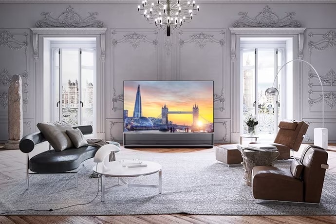 El televisor LG SIGNATURE OLED 8K se coloca en la habitación con cornisas victorianas y suelos de parqué, con los artículos de mobiliario de Flexform.