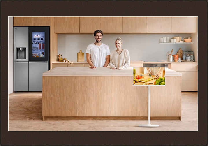 Imagen de una cocina ordenada y una pareja mirando de frente con sonrisas felices.