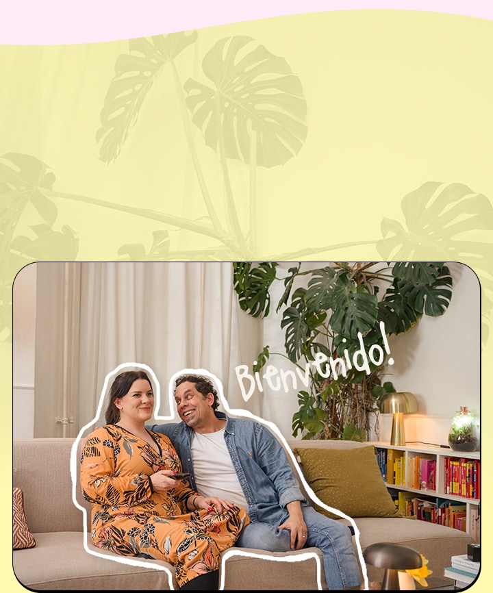 Es una imagen de una pareja sentada en un sofá viendo televisión.	