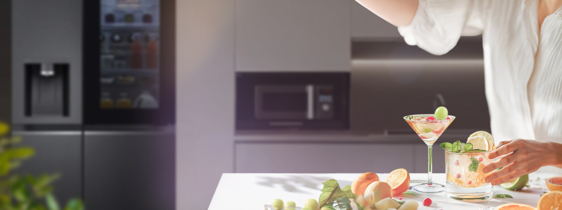 Una mujer prepara un cóctel sin alcohol bien decorado en la cocina con ingredientes esparcidos sobre la mesa.