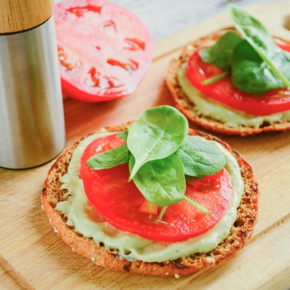 Pequeños platos adornados con albahaca fresca y tomates.