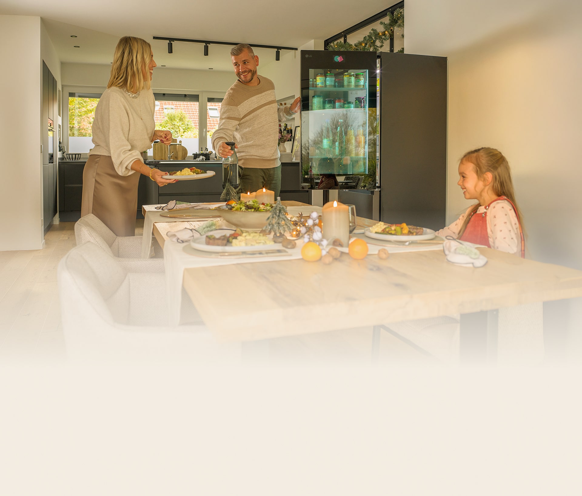 Una familia disfruta preparando una comida festiva con el frigorífico LG InstaView.