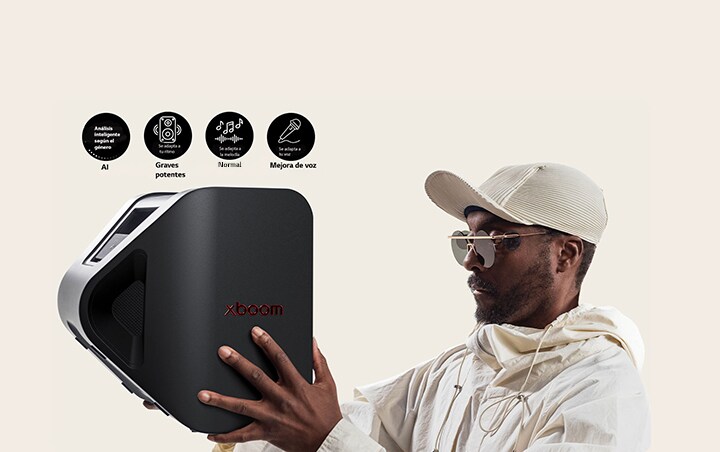 will.i.am con traje blanco y gorra blanca sostiene el xboom Stage 301 con ambos brazos en la cara.