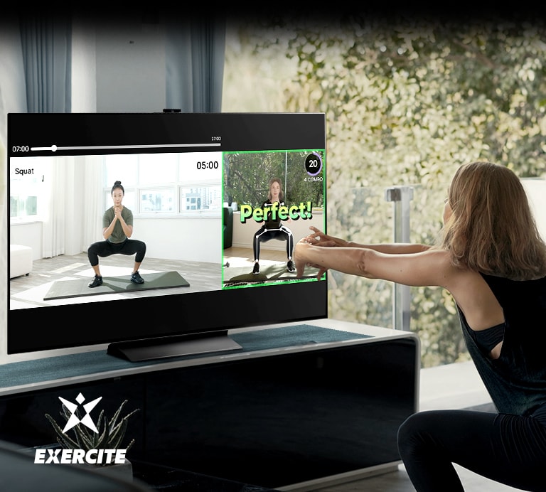 Una mujer está haciendo sentadillas mientras mira el televisor. Dentro de la pantalla, se ven imágenes que enseñan el ejercicio y comprueban tu postura.