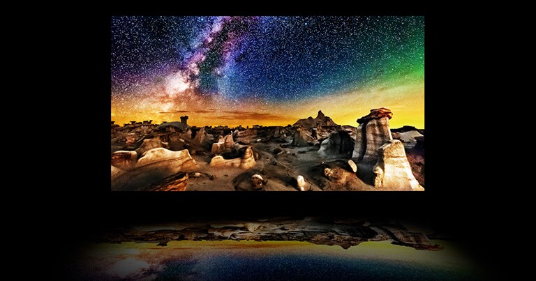 Une vidéo des couches de téléviseur avec une photo d'un paysage nocturne étoilé sur l'écran OLED principal. Le rétroéclairage disparaît et le polariseur, le filtre de couleur et l'OLED se combinent pour produire une image si brillante qu'elle se reflète sous la télévision comme sur de l'eau.
