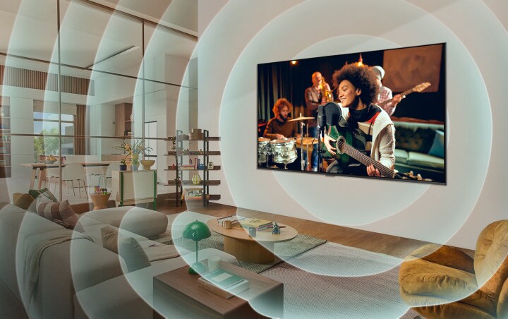 Le TV LG dans un appartement moderne. Une grille apparaît sur l’image comme un scan de l’espace, puis des ondes sonores bleues se projettent depuis l’écran, remplissant toute la pièce de son.