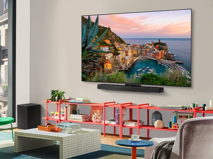 Dans un salon coloré se trouve une LG OLED TV murale avec Soundbar. La perspective est inclinée, montrant le cadre ultra fin de la TV contre le mur.