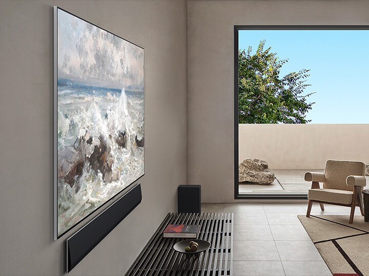 Salon dans une maison haut de gamme. Vue latérale inclinée d’une LG OLED TV murale. On voit qu’il n’y a aucun écart entre la TV et le mur*. 