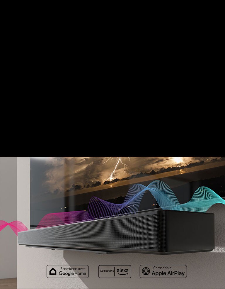La barre de son est accrochée au mur avec le téléviseur juste au-dessus d’elle. Des ondes sonores passent entre les deux appareils, changeant leurs couleurs du rouge au bleu.