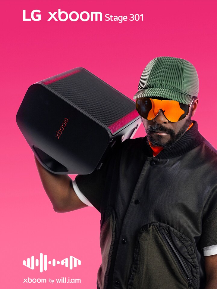 will.i.am en tenue noire et lunettes de soleil tient la xboom Stage 301 sur son épaule.