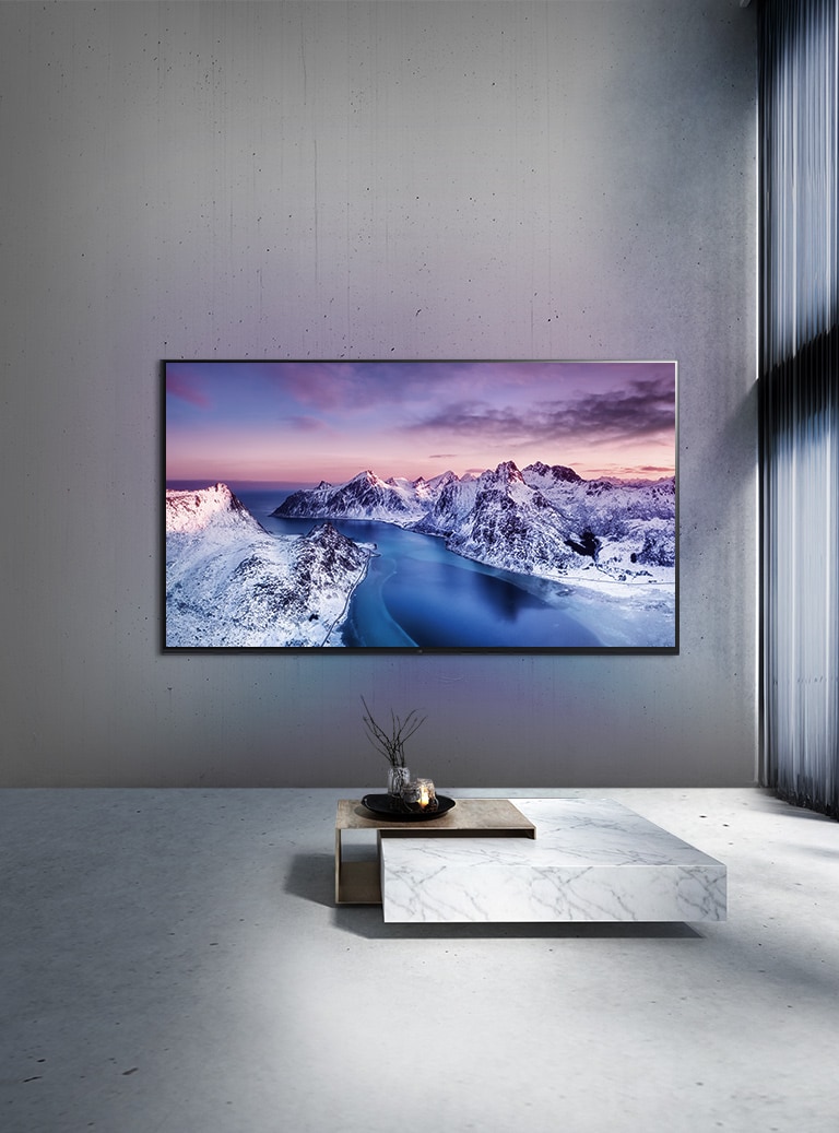 Un téléviseur UHD fixé au mur derrière une table décorée dans un style zen.