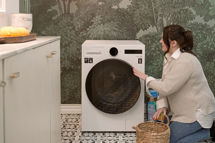 La vidéo montre la femme mettant du linge dans la machine à laver, la femme utilisant la machine à laver et le bouton de la machine à laver.	