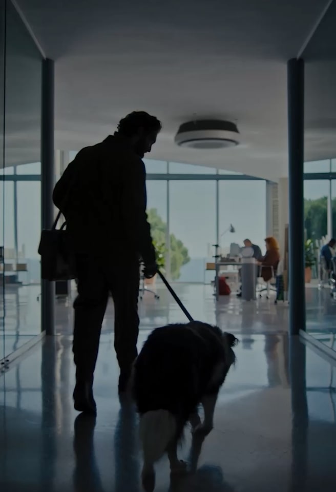 A man walks into the office holding a dog leash. A man in the driver's seat looks sad as LG AI shows him a family photo. The car display is shown in a close-up as LG AI pulls up a map and revisits a memory.