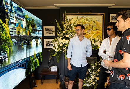 Three male attendees of SIGNATURE’s Goodwood event take a closer look at the clear, vivid imagery provided by the LG SIGNATURE 77-inch OLED TV.