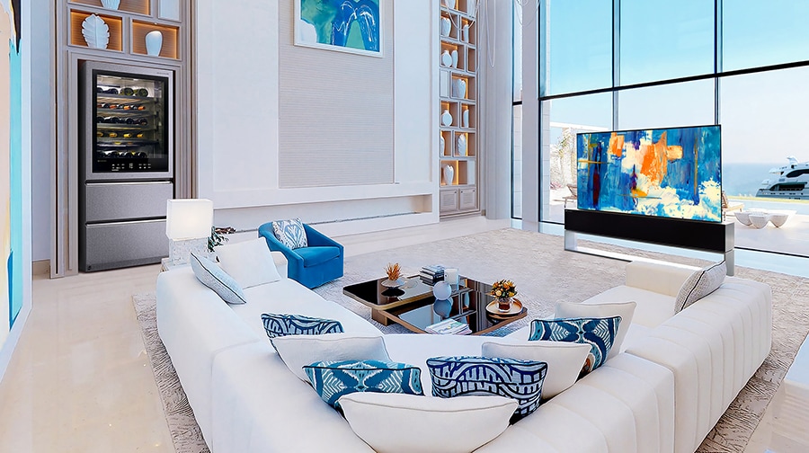 A Rollable OLED TV R in a white-and-blue themed room in front of large windows with a view of the ocean.