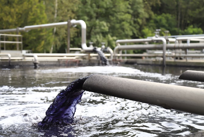 Indigo water pours from a pipe.