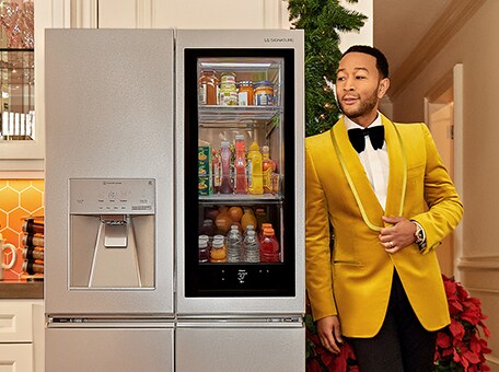Singer John Legend leaning on an LG SIGNATURE Refrigerator.