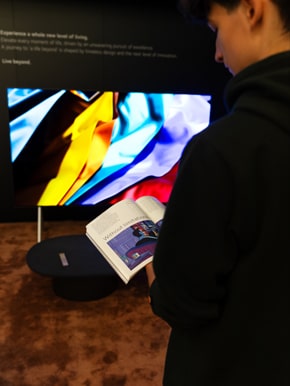 A visitor of the exhibition is shown reading the Monocle magazine at the LG SIGNATURE exhibition.