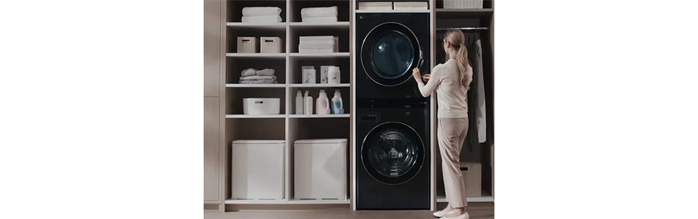 A woman opening up the door of LG Dryer which is the part of LG WashTower