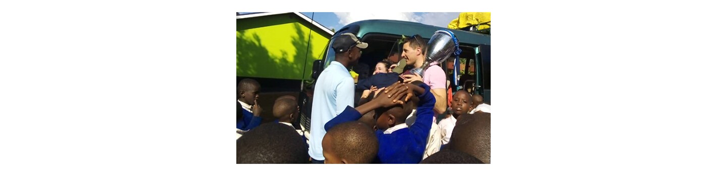 FC Cambounet being greeted at an elementary school in the village of Mbokomu, Tanzania, where they donated educational, technological and sporting equipment.