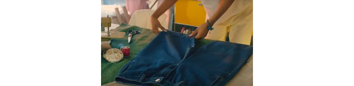 Someone measuring a pair of jeans before transforming it into a whole new design.