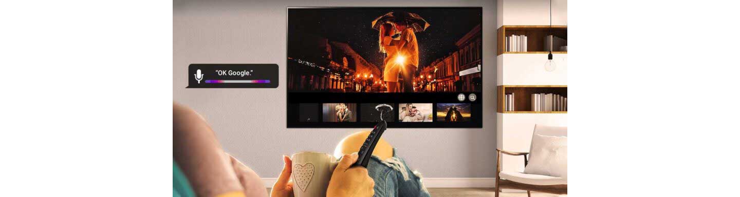 A woman relaxes on the couch as she selects which romantic movie to watch next on her LG TV via Google Assistant.