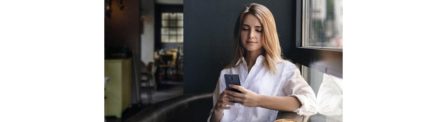 A woman uses her LG smartphone in the home