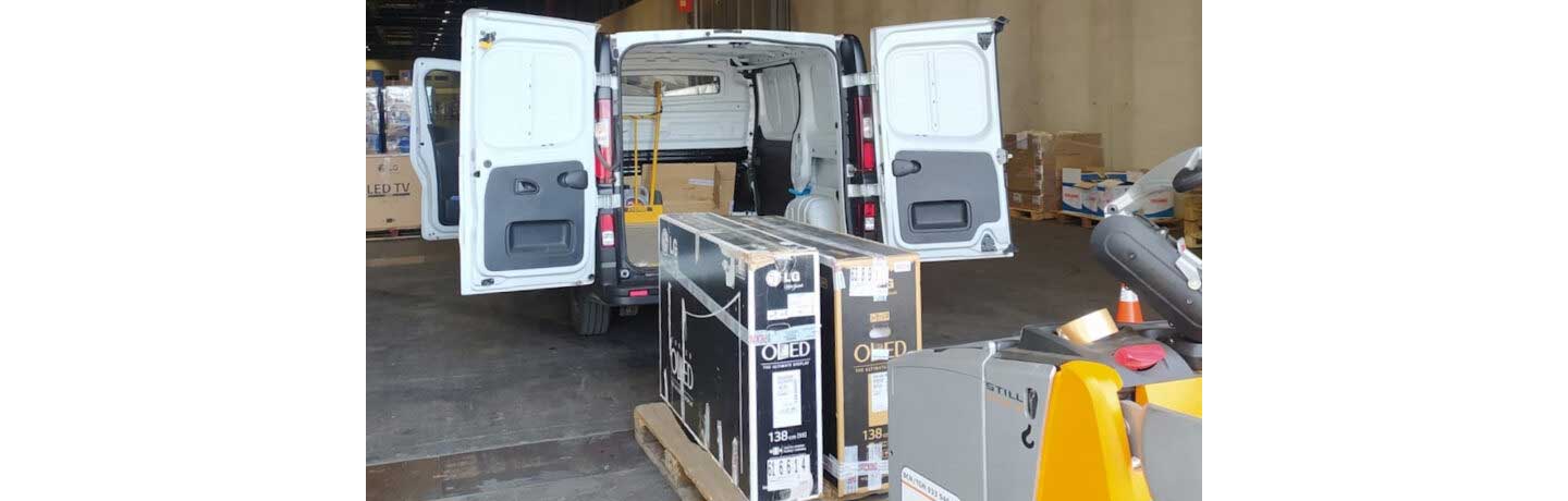 LG OLED TVs being loaded into the back of a van