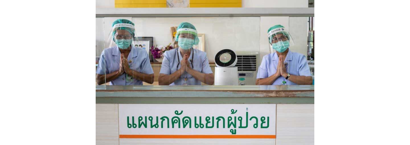 Three medical workers showing their gratitude in front of an LG PuriCare air purifier