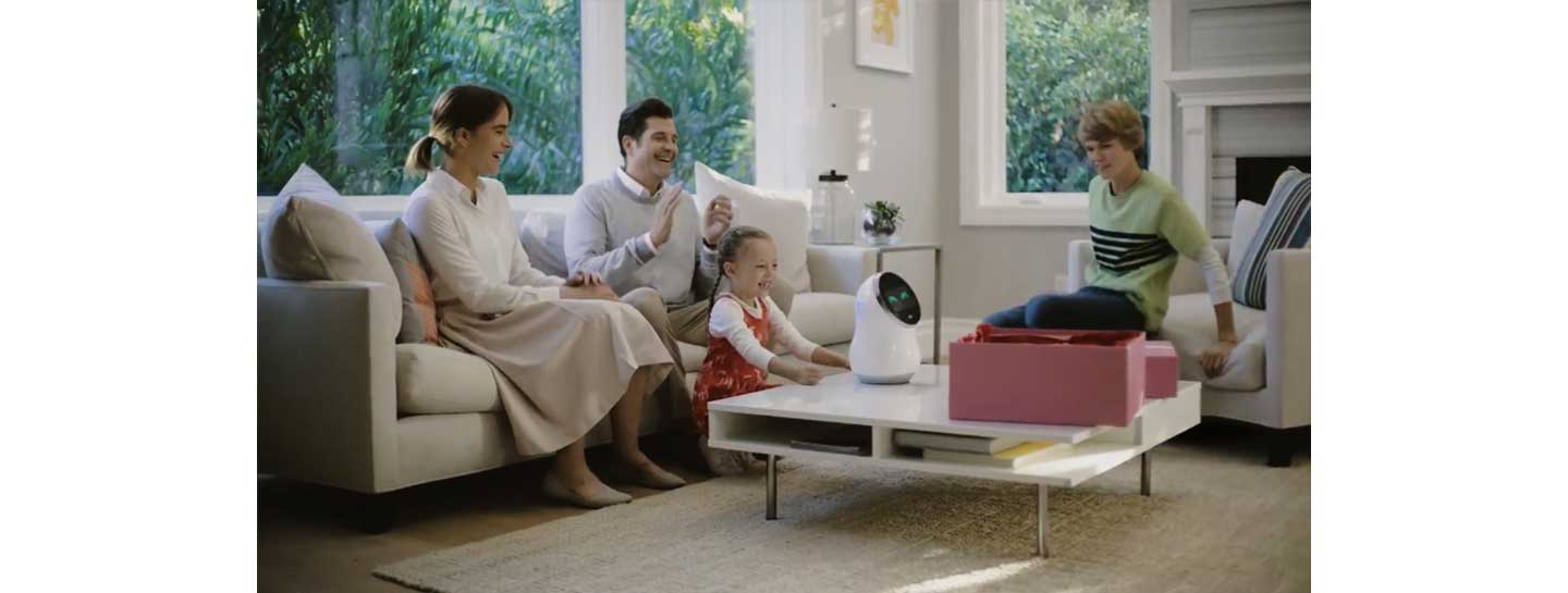 Four members of a family enjoy their time together using LG’s CLOi Hub Robot in the living room.