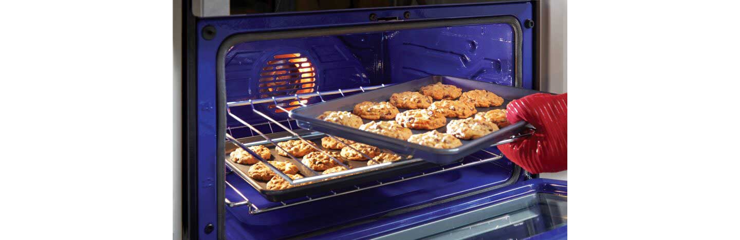 A tray of cookies is being taken from the LG Oven, with baking made easy via its LG ProBake Convection®