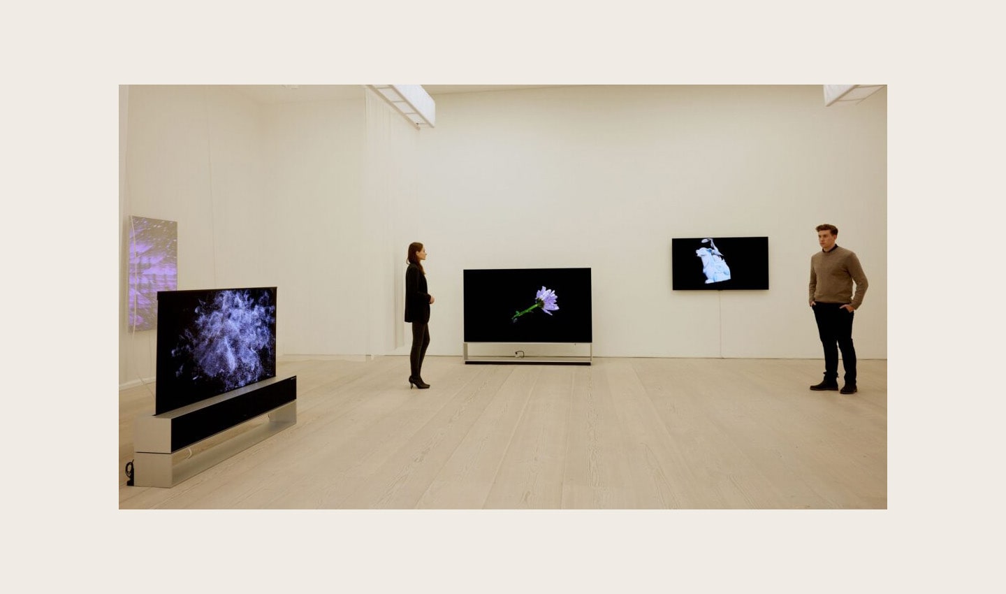 Two visitors viewing ‘The Moment & Morpho Luna’ by Je Baak displayed on LG OLED TVs