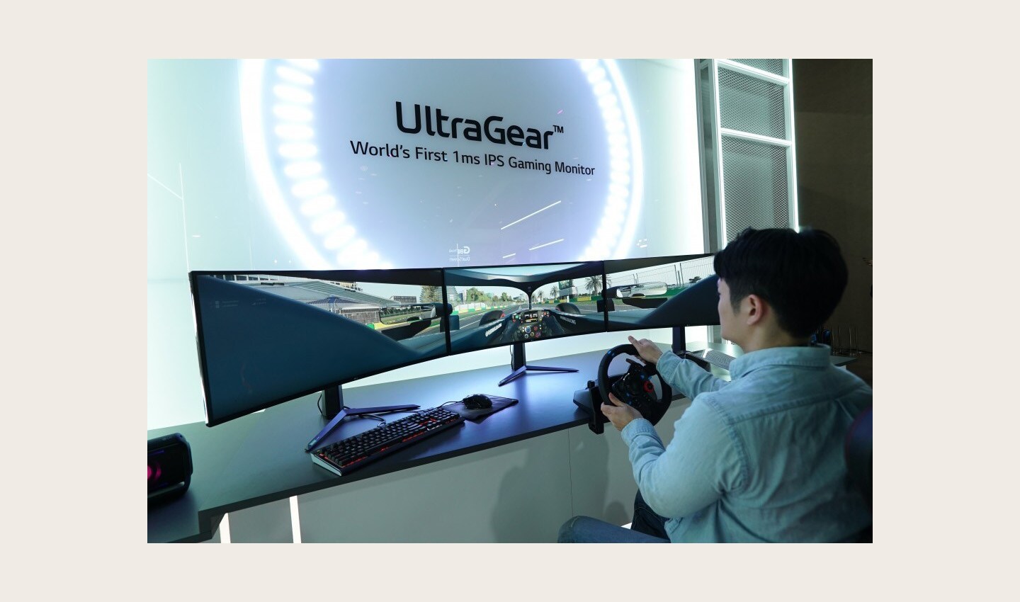 A visitor uses three wide LG UltraGear monitors side-by-side to experience an immersive racing game setup at CES 2020 with record-breaking 1ms response rates