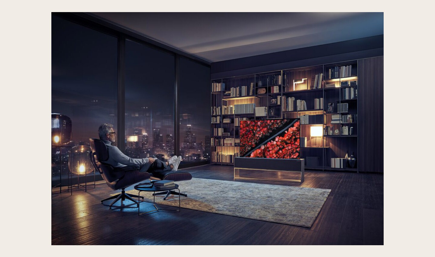 A man is relaxing in a chair at night, watching a nature scene on an LG SIGNATURE OLED TV R