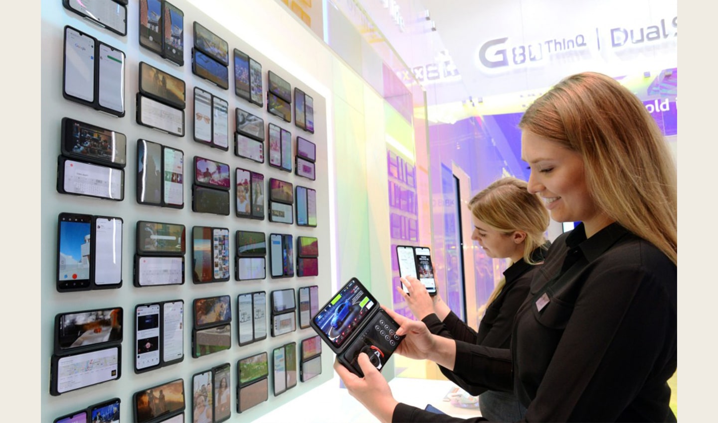 Two female models hold up the LG G8X ThinQ smartphones at LG’s IFA booth, which demonstrates all the new features of LG G8X ThinQ.